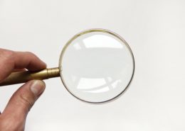 A magnifying glass on top of a white piece of paper