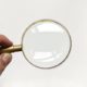 A magnifying glass on top of a white piece of paper