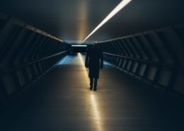 A man walking through a dark tunnel