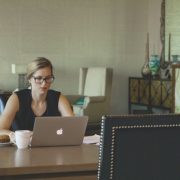 A business woman in a room working on her laptop